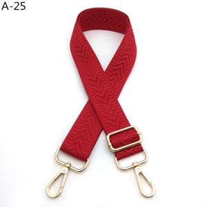 Detail of red chevron woven bag strap with adjustable gold metal buckle and hooks