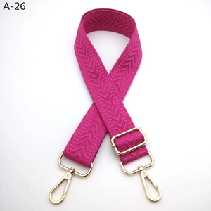 Detail of magenta patterned replacement bag strap with golden metal buckles and V-wave texture