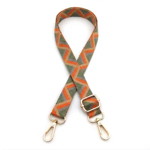 Close-up of geometric patterned colorful bag strap with golden metal lobster clasps