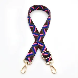 Detail of adjustable geometric woven shoulder strap with gold metal swivel hooks