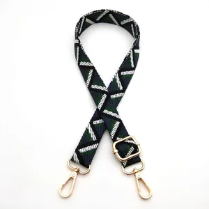 Detail view of the blue and green geometric woven shoulder strap with gold metal hooks