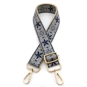 Close-up of ethnic style jacquard bag strap with blue floral pattern and gold metal hooks