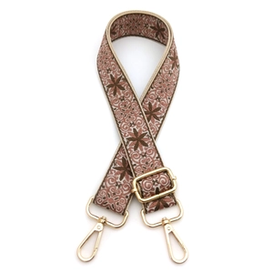 Close-up of ethnic jacquard bag strap with geometric patterns and golden metal hooks