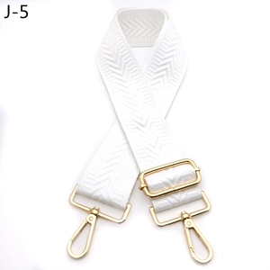 Detail of adjustable white herringbone bag strap with golden metal lobster clasps