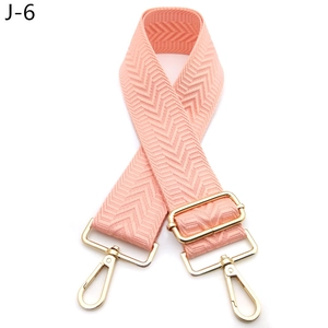 Detailed view of pink chevron webbing bag strap with adjustable gold-tone metal hardware
