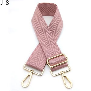 Detailed view of pink woven bag strap with golden metal carabiner and adjustable buckle