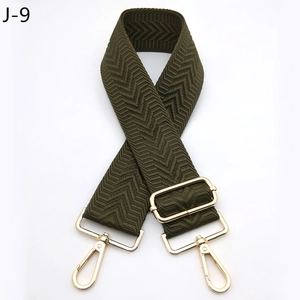 Macro view of army green wide strap with chevron pattern and gold metal buckles