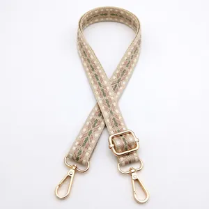 Detail of bohemian geometric woven bag strap with golden lobster clasps and adjusters