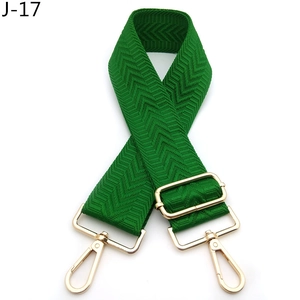 Detail of green herringbone patterned bag strap with gold adjustable metal buckles