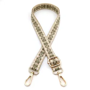 Close-up of adjustable woven strap with beige diamond patterns and gold metal hardware
