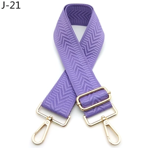Detail view of purple arrow patterned strap with gold metal buckle for bags
