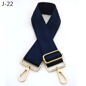 Detail view of navy blue chevron patterned bag strap with golden metal swivel hooks
