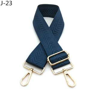 Detail of dark blue arrow pattern woven strap with gold metal hooks and adjustable slider