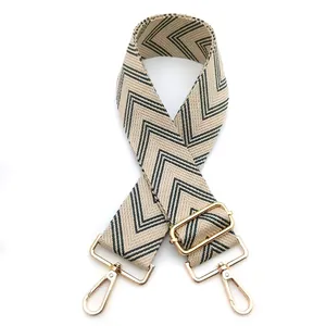 Close-up of beige and grey zigzag pattern bag strap with gold metal hardware