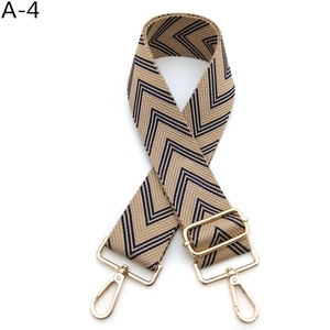 Detail of beige and navy chevron pattern wide strap with polished gold-tone metal clips