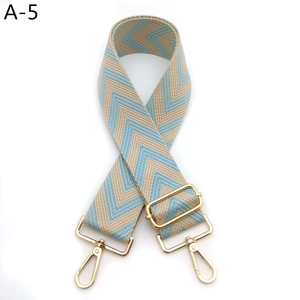 Detail view of the blue and beige geometric pattern weaving on the wide adjustable bag strap