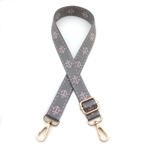 Adjustable gray woven bag strap with pink anchor pattern and gold metal hardware