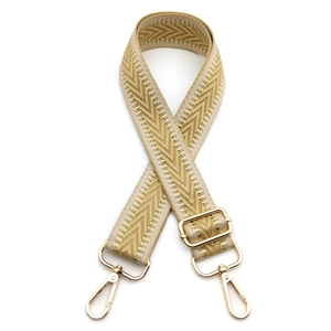 Detail of adjustable beige chevron jacquard strap with gold metal swivel hooks and hardware