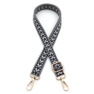 Detail of adjustable geometric arrow pattern bag strap with gold metal lobster clasps