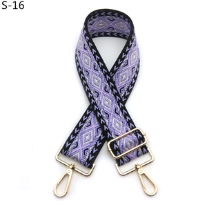 Detailed view of purple geometric jacquard bag strap with gold metal hooks and buckle