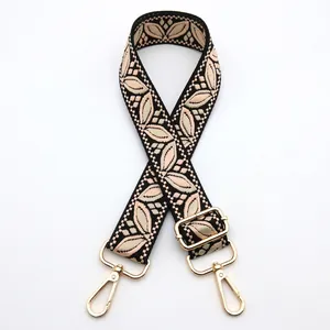 Detail of adjustable floral jacquard bag strap with golden metal lobster clasps