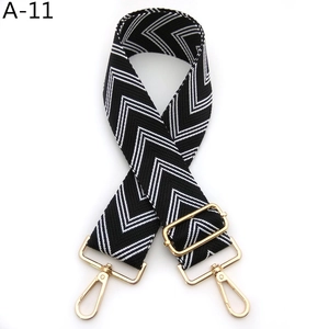 Detail view of adjustable herringbone pattern bag strap with polished gold hardware