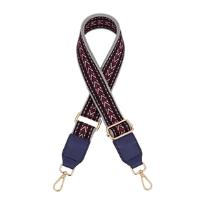 Close-up of adjustable woven shoulder strap with geometric patterns and gold metal clips