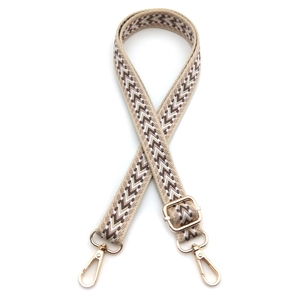Close-up of adjustable woven purse strap with brown chevron pattern and gold hardware