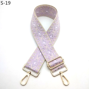 Detailed close-up of jacquard woven geometric strap with golden metal lobster clasps