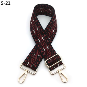 Detail of red and black jacquard geometric patterns on an adjustable crossbody strap