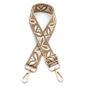 Detail of adjustable khaki ethnic floral embroidered shoulder strap with gold metal hooks
