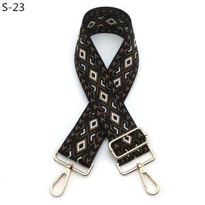 Detail of adjustable geometric jacquard bag strap with golden metal lobster clasps