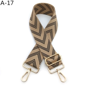 Close-up of adjustable woven shoulder strap with khaki chevron pattern and gold metal hooks