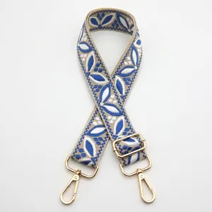 Detail of adjustable ethnic style bag strap with blue leaf pattern and gold hardware