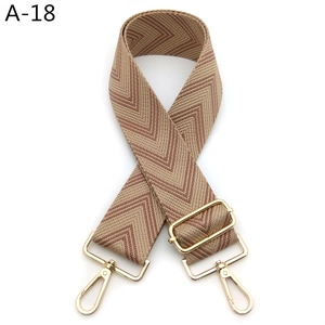 Detail of adjustable wide shoulder strap with camel and brown chevron pattern and gold metal hooks