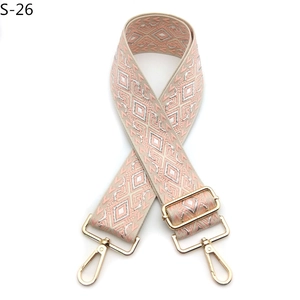 Close-up of pink and silver jacquard diamond pattern bag strap with gold metal lobster hooks