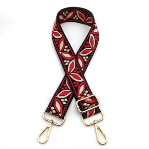 Close-up of bohemian style jacquard bag strap with red leaf pattern and gold metal hardware