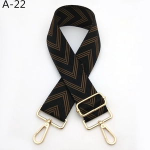Detail of adjustable chevron strap with black and brown patterns and gold metal hooks