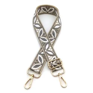 Detail of bohemian floral jacquard bag strap with golden metal lobster clasps