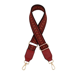 Detail of vintage arrow pattern woven strap with red faux leather and gold metal clips