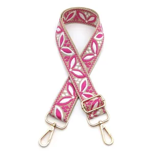 Close-up of pink floral jacquard strap with golden metal swivel hooks and adjuster