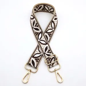Close-up of ethnic style jacquard bag strap with coffee leaf pattern and gold hardware