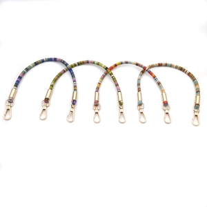 Close-up of colorful beaded phone wrist straps with golden metal lobster clasps on white background