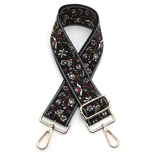 Detail of ethnic floral embroidery and gold metal lobster clasp on the black bag strap