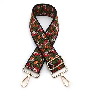 Close-up of ethnic embroidered bag strap with floral pattern and golden metal hardware