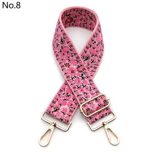 Close-up of pink floral embroidered wide strap with light gold metal swivel hooks