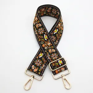 Close-up of bohemian embroidered strap with floral patterns and gold metal buckles