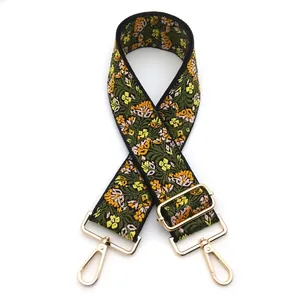 Close-up of ethnic style embroidered bag strap with golden metal lobster clasps and buckles