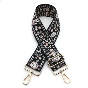 Close-up of ethnic style wide bag strap with floral embroidery and gold lobster clips