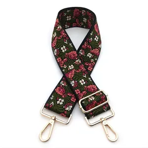 Close-up of vintage floral jacquard bag strap with gold metal lobster clasps and buckles